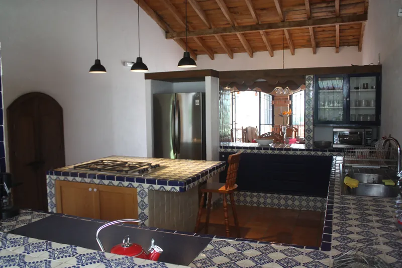 Cocina con barra de talavera, estufa de gas y refrigerador